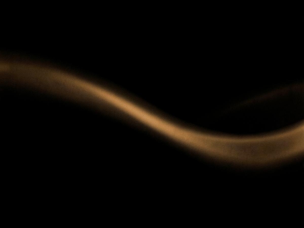 Onda de luz ámbar suave sobre un fondo oscuro